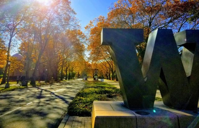 The "W" statue at the entrance to the UW campus, with fall-colored trees and the Jacobsen observatory in the background.
