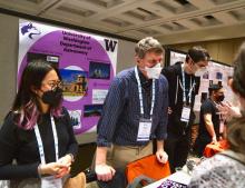 Debby Tran, Eric Agol, and Mario Juric speaking to students at the UW Astronomy table at the AAS conference. 